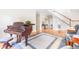 Elegant living room with hardwood floors, a grand piano, and a staircase view at 228 Birch Creek Dr, Fuquay Varina, NC 27526