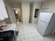 Bright kitchen features white cabinets, a white refrigerator, and tile flooring at 2505 Chapel Hill Rd, Durham, NC 27707