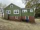 The rear of the home features a brick foundation and many windows at 2505 Chapel Hill Rd, Durham, NC 27707