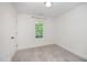 Neutral-toned bedroom featuring a large window, neutral carpet and white walls at 2801B Cannada Ave, Durham, NC 27704