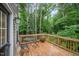 Wooden deck area with a table, chairs, and view of the wooded backyard at 2801B Cannada Ave, Durham, NC 27704