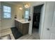 A bathroom featuring double sinks, a large mirror, and an open walk-in closet at 30 Junius Birch Trl, Franklinton, NC 27525