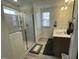 A well-lit bathroom featuring double sinks, a glass-enclosed shower, and neutral decor at 30 Junius Birch Trl, Franklinton, NC 27525
