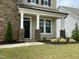 Inviting front porch with stone pillars and manicured landscaping leading to the front door at 30 Junius Birch Trl, Franklinton, NC 27525