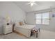 Bright bedroom featuring a queen-sized bed, bench, neutral walls, and a ceiling fan for added comfort at 3021 White Cloud Cir, Apex, NC 27502
