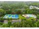 Aerial view of community amenities including tennis courts, basketball court, and a pool surrounded by trees at 3021 White Cloud Cir, Apex, NC 27502