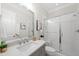 Bright bathroom with a glass-enclosed shower, quartz counters, modern fixtures, and a large mirror at 329 Broad Elm Ln, Apex, NC 27523