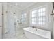 Luxurious bathroom with a freestanding tub, glass shower, and elegant marble tile for a spa-like retreat at 329 Broad Elm Ln, Apex, NC 27523