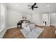 Bright bedroom features a ceiling fan, hardwood floors, and is decorated with neutral tones and modern art at 329 Broad Elm Ln, Apex, NC 27523