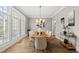 Cozy dining room with natural light from large windows, modern light fixture, and hardwood flooring at 329 Broad Elm Ln, Apex, NC 27523