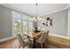 Elegant dining room features a chandelier, large windows, and comfortable seating for formal occasions at 329 Broad Elm Ln, Apex, NC 27523