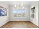 Light-filled dining room boasts large windows, modern light fixture, and beautiful hardwood floors at 329 Broad Elm Ln, Apex, NC 27523