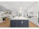 Bright, open kitchen features a large center island, modern appliances, and seamless flow to the living area at 329 Broad Elm Ln, Apex, NC 27523