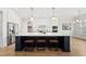 Modern kitchen features a large island with seating, stainless steel appliances, and custom cabinetry at 329 Broad Elm Ln, Apex, NC 27523