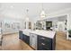 Open-concept kitchen with a large island, pendant lighting, and seamless flow to the living room at 329 Broad Elm Ln, Apex, NC 27523