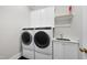 Laundry room with white cabinets, modern washer/dryer, and a utility sink at 329 Broad Elm Ln, Apex, NC 27523