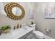 A stylish powder room featuring a marble countertop, elegant fixtures, and a decorative mirror at 329 Broad Elm Ln, Apex, NC 27523