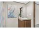 Well-lit bathroom with a single vanity, shower with curtain, and decorative peacock art at 332 Eastfield Dr, Rocky Mount, NC 27801