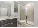 Bathroom featuring a vanity with stone countertop, toilet, and tiled shower with a glass door at 352 Fire Opal Ln, Holly Springs, NC 27540