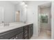 Modern bathroom with double sinks, dark cabinets, and a view of the outdoors at 352 Fire Opal Ln, Holly Springs, NC 27540