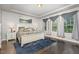 Spacious main bedroom with a trey ceiling, two windows with decorative curtains and wood floors at 352 Fire Opal Ln, Holly Springs, NC 27540