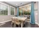 Inviting dining area with sliding glass doors to a screened porch, complemented by windows and wood floors at 352 Fire Opal Ln, Holly Springs, NC 27540