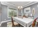 Dining room featuring neutral walls with white trim, elegant chandelier, and large windows at 352 Fire Opal Ln, Holly Springs, NC 27540