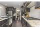 Modern kitchen featuring dark wood cabinets, stainless steel appliances, and granite countertops at 352 Fire Opal Ln, Holly Springs, NC 27540