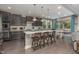 Stylish kitchen island with dark cabinets, granite countertops, pendant lights, and bar seating at 352 Fire Opal Ln, Holly Springs, NC 27540