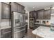 Modern kitchen featuring stainless steel appliances, dark cabinets, and granite countertops at 352 Fire Opal Ln, Holly Springs, NC 27540