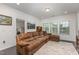 Cozy living room features a brown sectional sofa, large area rug, and bright windows at 352 Fire Opal Ln, Holly Springs, NC 27540