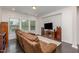 Cozy living room featuring a plush, reclining sofa and large windows for ample natural light at 352 Fire Opal Ln, Holly Springs, NC 27540