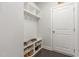 Functional mudroom with built-in shoe storage, coat hooks, and a white door at 352 Fire Opal Ln, Holly Springs, NC 27540