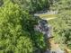 A view of the home nestled among lush green trees, offering privacy and a serene setting at 3911 Hope Valley Rd, Durham, NC 27707