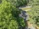 A view of the home nestled among lush green trees, offering privacy and a serene setting at 3911 Hope Valley Rd, Durham, NC 27707