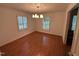 Empty dining room with hardwood floors, neutral walls, and a modern light fixture at 3911 Hope Valley Rd, Durham, NC 27707