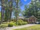 Charming brick home with lush landscaping and a paved driveway, nestled among mature trees at 3911 Hope Valley Rd, Durham, NC 27707