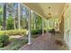 Inviting front porch with brick flooring, classic columns, and lush greenery at 3911 Hope Valley Rd, Durham, NC 27707