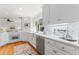 Bright, white kitchen with updated appliances, quartz countertops, and a view to the backyard at 3911 Hope Valley Rd, Durham, NC 27707