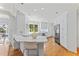 Spacious white kitchen featuring stainless steel appliances, hardwood floors, and a breakfast bar at 3911 Hope Valley Rd, Durham, NC 27707