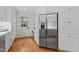 Modern kitchen featuring stainless steel refrigerator, white cabinets, and hardwood floors at 3911 Hope Valley Rd, Durham, NC 27707