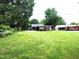 Expansive backyard featuring a covered patio area and lush green lawn for recreation and relaxation at 404 Oakgrove Dr, Graham, NC 27253