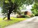 Quaint single-story home with brick accents, a well-manicured lawn, and a long driveway at 404 Oakgrove Dr, Graham, NC 27253