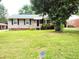 Well-kept front yard and charming single-story house with black shutters and a manicured lawn at 404 Oakgrove Dr, Graham, NC 27253