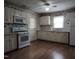 Charming kitchen with white cabinets, floral wallpaper, and matching appliances at 404 Oakgrove Dr, Graham, NC 27253