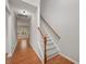 Bright hallway with hardwood floors, carpeted stairs, and access to multiple rooms at 404 Straywhite Ave, Apex, NC 27539