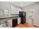 Modern kitchen with black appliances, white cabinets, and view into the dining room at 404 Straywhite Ave, Apex, NC 27539