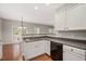 Spacious kitchen with stainless sink, black dishwasher, white cabinets, and hardwood floors at 404 Straywhite Ave, Apex, NC 27539