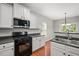 Well-equipped kitchen with sleek black appliances, white cabinetry, and hardwood floors at 404 Straywhite Ave, Apex, NC 27539