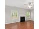 Cozy living room featuring a fireplace, hardwood floors, large windows, and a ceiling fan at 404 Straywhite Ave, Apex, NC 27539